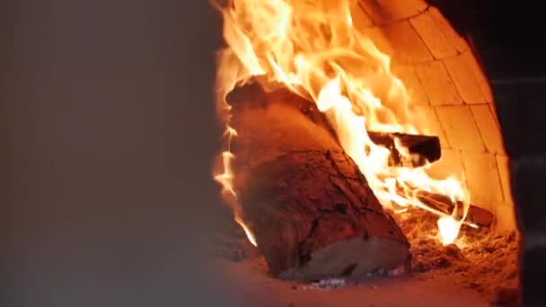 Close-up Movement with a slider as in a pizza oven burns freshly freshly thrown firewood just fine. Place the pizza in a wood-burning pizza oven using the pizza peel. — Stock Video