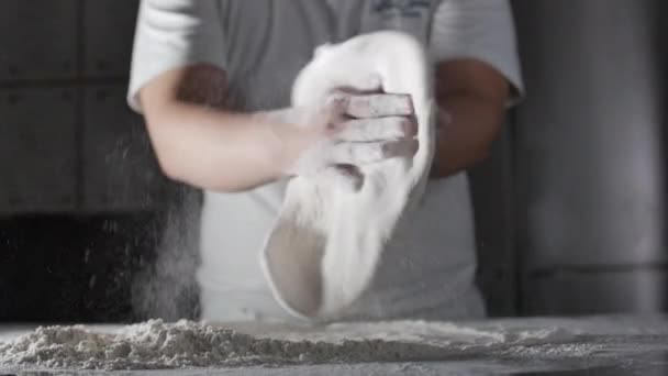 Farinha cai das mãos de um chef italiano em uma cozinha profissional preparando uma massa com farinha para fazer pizza italiana. — Vídeo de Stock