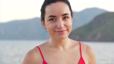 Melez bir genç kızın portresi güzel dağların ve mavi denizin doğasının arka planı. Tropikal bir plajda Avrupalı Güzel Kız 'ın Yakın Çekim Portresi.