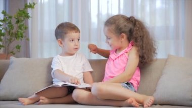 Tatlı çocuklar, küçük erkek kardeşi olan kız kardeş, bir kitap dergisi sözlüğü sözlüğüne bakıyor, peri masalları okuyor, çocuklar kanepede oturuyor, anaokulu ve okul eğitimi alıyor..