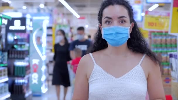 Porträt einer Europäerin in einer Maske von einer Coronavirus-Epidemie kauft im Supermarkt ein, wählt Toilettenpapier, Menschen in Panik vor der globalen Epidemie kaufen alles Covid-19,