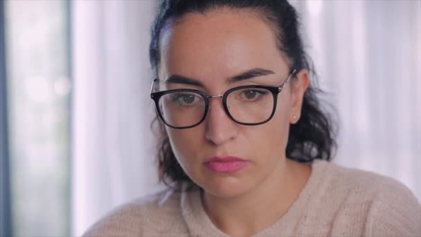 Joven mujer seria freelancer trabajando en una computadora portátil sentada en un sofá en casa, mujer de negocios escribiendo en una computadora portátil, chica enfocada usando una computadora para estudiar trabajo en línea en casa. Concepto de trabajo del empleado doméstico — Vídeos de Stock