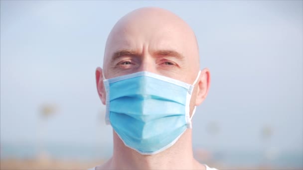 一个年轻男子在街上戴着保护面罩，戴着ovid-19面罩的画像。Health and safety concept, N1H1 coronavirus, virus protection, pandemic in World. — 图库视频影像