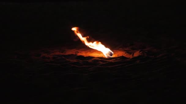 人在夜里站着,把胳膊摆动到侧面的火球上.晚上在街上失火的专业艺术家. — 图库视频影像
