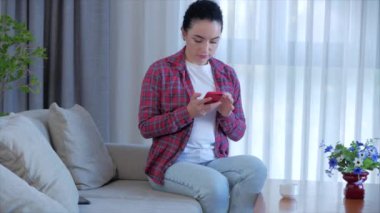 Evdeki koltukta oturan bir kadın, evde oturan bir iş kadını, akıllı telefonlu posta kutusunda oturup evde internetten öğrenim görüyor..