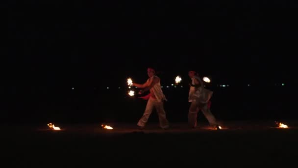 Artistas profissionais organizaram um show noturno na praia de areia, entretendo visitantes de cafés e restaurantes à beira-mar acenando bolas de fogo em Nha Trang, Vietnã, 8 de maio de 2020 . — Vídeo de Stock