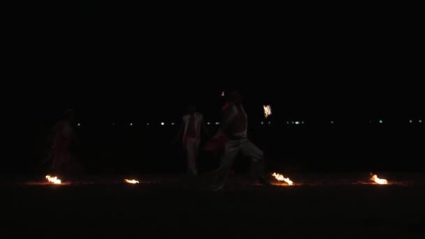 Профессиональные художники устроили ночное шоу на песчаном пляже, развлекая посетителей кафе и ресторанов у моря размахивая огненными шарами в Нячанге, Вьетнам, 8 мая 2020 года . — стоковое видео