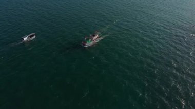 Profesyonel balıkçı teknesi, balık tuttuktan sonra sabah gün ışığında limana döner. Yüksek hızda mürekkep balığı ve ıstakoz avlamak için yengeç tuzakları olan bir balıkçı teknesinin insansız hava aracından ateş eder.