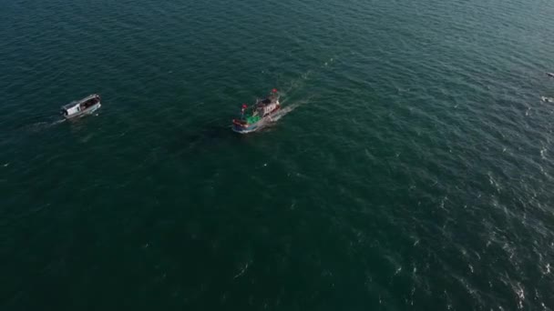 Professional fishing vessel returns to the port in the morning in the sunshine after fishing,shooting from drone of an Asian fishing schooner a boat with crab traps for squid and lobster at high speed — Stock Video