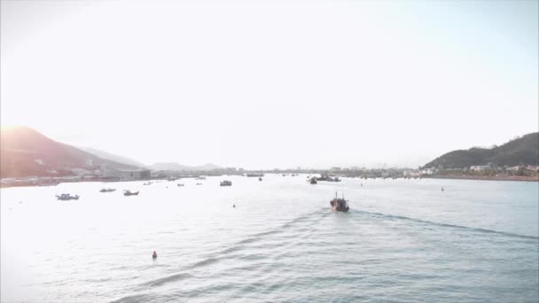 Professionella fiskefartyg återvänder till hamnen på morgonen i solskenet efter fiske, skjuter från drönare av en asiatisk fiskekonare en båt med krabbfällor för bläckfisk och hummer i hög hastighet — Stockvideo