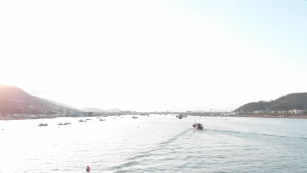 Professional fishing vessel returns to the port in the morning in the sunshine after fishing,shooting from drone of an Asian fishing schooner a boat with crab traps for squid and lobster at high speed — Stock Video