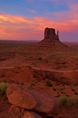Monument Valley günbatımı, pembe gökyüzü ve kırmızı toprak