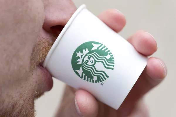 Ein unbekannter Mann hält eine Tasse mit Getränken aus einem Starbucks-Café in New York — Stockfoto