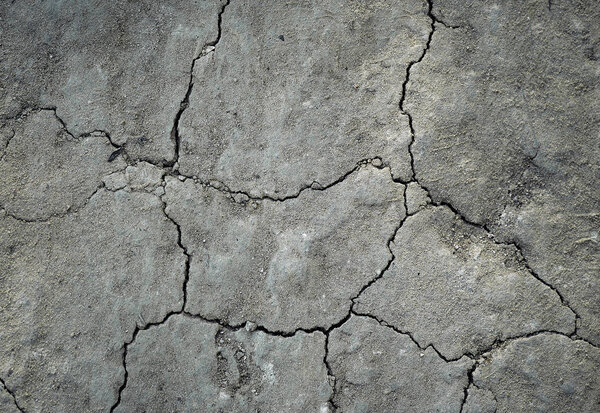 Серый трещины почвы для фона или текстур
