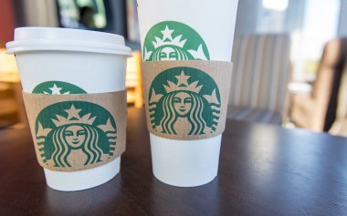Kağıt bardak ahşap masa bir Starbucks Cafe'de Starbucks logo ile
