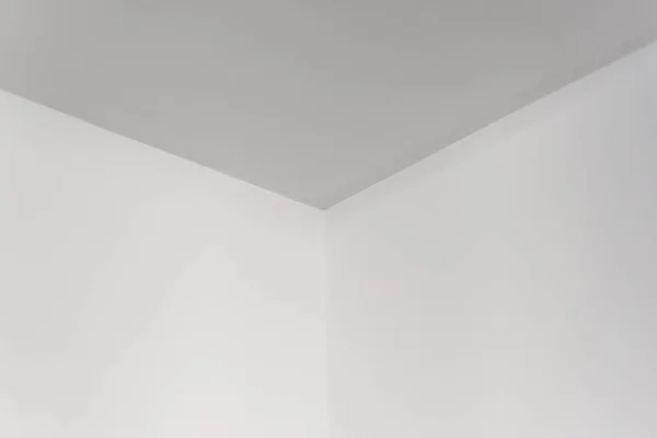 Empty white room corner, white surface of ceiling