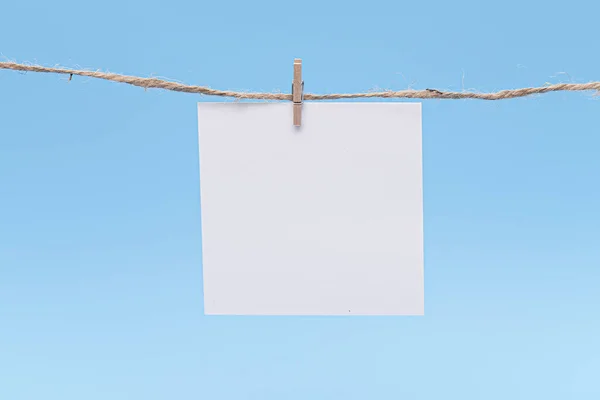 Papel Blanco Colgando Cuerda Por Perno Contra Fondo Azul Concepto —  Fotos de Stock