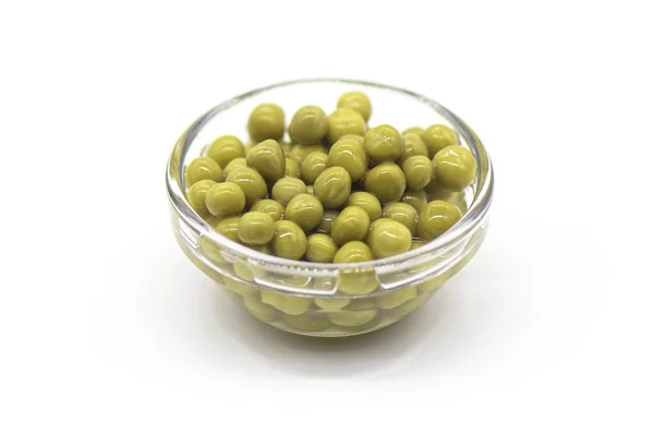 白地に隔離されたガラスボウルに缶詰の緑のエンドウ豆背景 — ストック写真