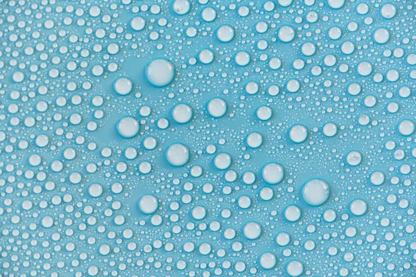 Mavi yüzeye yakın su damlaları, yağmur damlaları, arkaplan veya doku