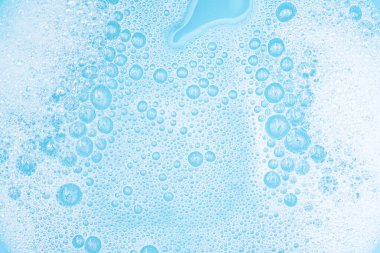 Su yüzeyinde köpüklü beyaz köpük, sabun ve mavi banyoyla yıkama tozu, soyut şeffaf arka plan kabarcığı.