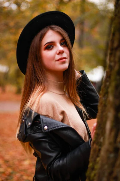 Élégante fille d'automne dans le parc. Pull, chapeau et veste en cuir — Photo