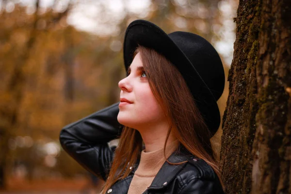 Stylová podzimní dívka v parku. Svetr, klobouk a kožená bunda — Stock fotografie