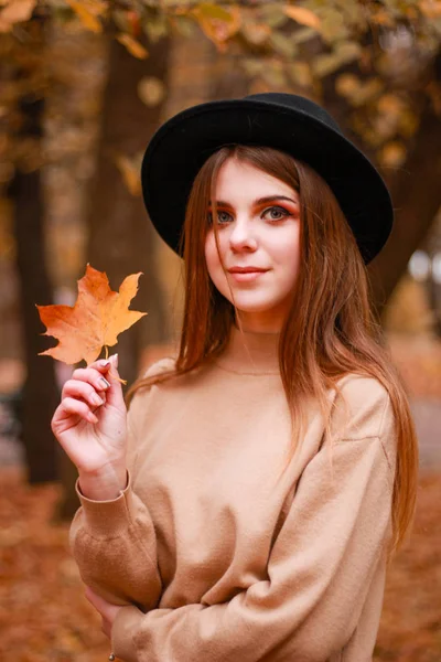 公園の秋の女の子。セーター、帽子、革のスカート。スタイリッシュ — ストック写真