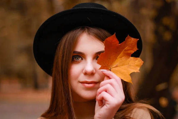 Herfst meisje in het park. Trui, hoed en leren rok. Stijlvol — Stockfoto