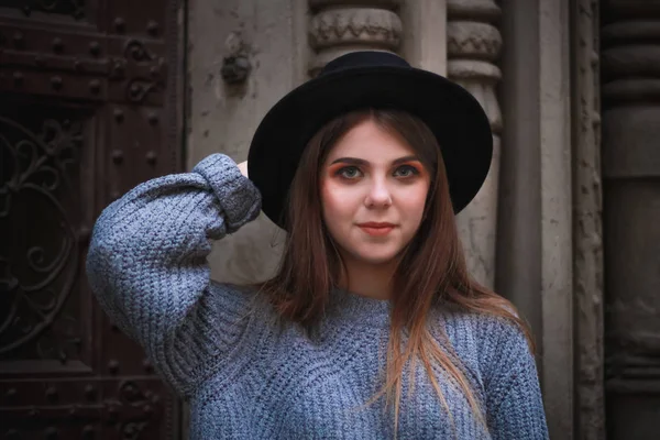 Стильна осіння дівчина в центрі старого міста. светр, капелюх — стокове фото