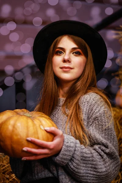 Κομψό φθινοπωρινό κορίτσι με κολοκύθα. Πουλόβερ, καπέλο. Απόκριες σύντομα. — Φωτογραφία Αρχείου