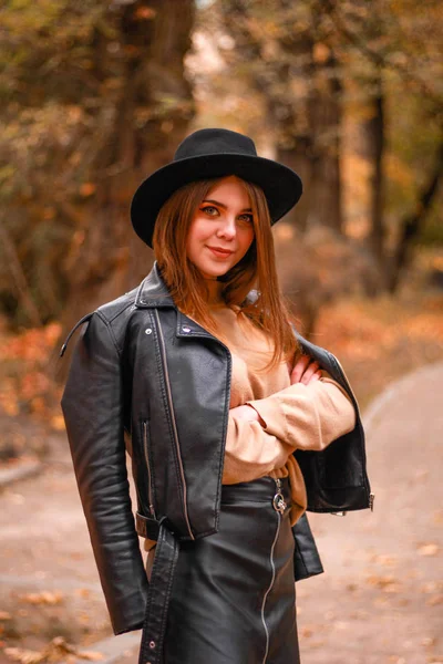 Elegante chica de otoño en el parque. Suéter, sombrero y chaqueta de cuero —  Fotos de Stock