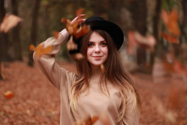 Το κορίτσι του φθινοπώρου στο πάρκο. Πουλόβερ, καπέλο και δερμάτινη φούστα. Κομψό — Φωτογραφία Αρχείου