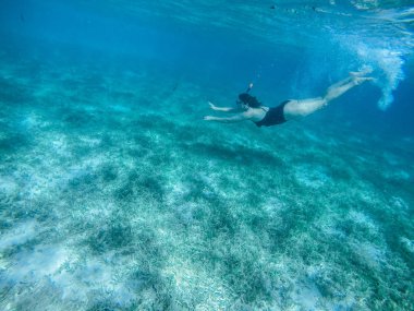 Kızıl denize dalıyorum. Bikinili ve maskeli seksi kız. Şnorkelleme.