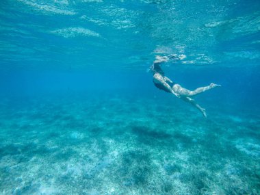 Kızıl denize dalıyorum. Bikinili ve maskeli seksi kız. Şnorkelleme.