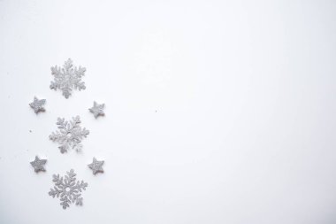 Noel çerçevesi gümüş yıldızları beyaz arka planda yaptı. Kış konsepti Düz konum, üst görünüm, kopyalama alanı. Noel kompozisyonu. 