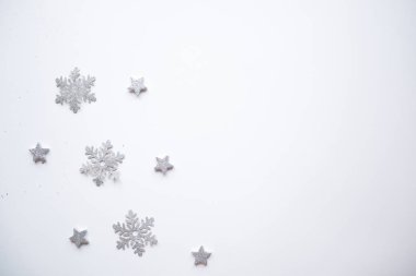 Noel çerçevesi gümüş yıldızları beyaz arka planda yaptı. Kış konsepti Düz konum, üst görünüm, kopyalama alanı. Noel kompozisyonu. 