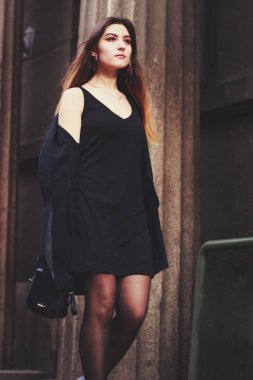 Siyah elbiseli ve uzun ceketli bir manken. Tarz. Moda eğilimleri 2020