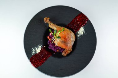 Ördek bacağı, lahanalı ve ahududu soslu. Siyah pla