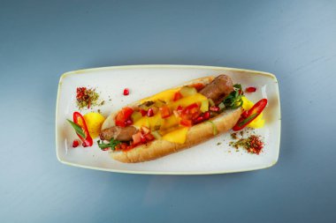 Gerçek Bavyera sosisi ve çedar peynirli sosisli sandviç. Beyaz pla