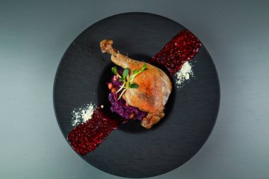 Ördek bacağı, lahanalı ve ahududu soslu. Siyah pla