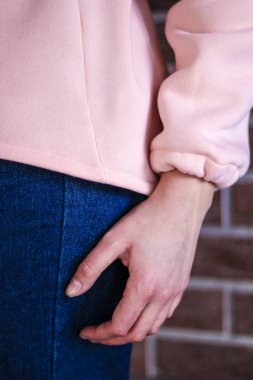 Toz kazaklı bir kız. Açık pembe kazak. Sıcak kapüşonlu. Urba