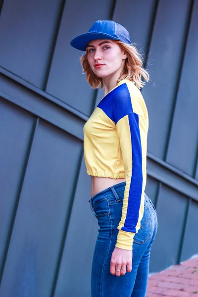 Girl in a yellow-blue crop top. Stylish streetwear for teens. Sh — 스톡 사진