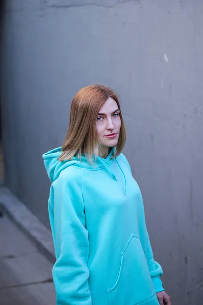 Ragazza in maglione lungo blu. Felpa con cappuccio alla menta. Pubblicità per abbigliamento — Foto Stock