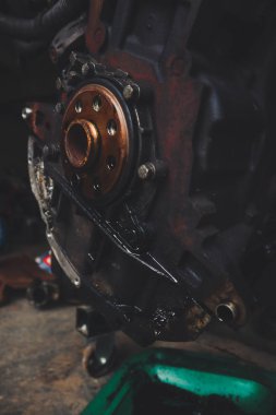 Tamirhanede araba motoru üzerinde çalışan bir tamirci. Tamir servisi. Yakın plan, koyu arkaplan