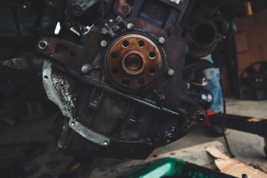 Tamirhanede araba motoru üzerinde çalışan bir tamirci. Tamir servisi. Yakın plan, koyu arkaplan