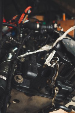 Tamirhanede araba motoru üzerinde çalışan bir tamirci. Tamir servisi. Yakın plan, koyu arkaplan