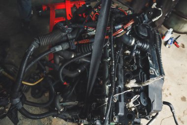 Tamirhanede araba motoru üzerinde çalışan bir tamirci. Tamir servisi. Yakın plan, koyu arkaplan