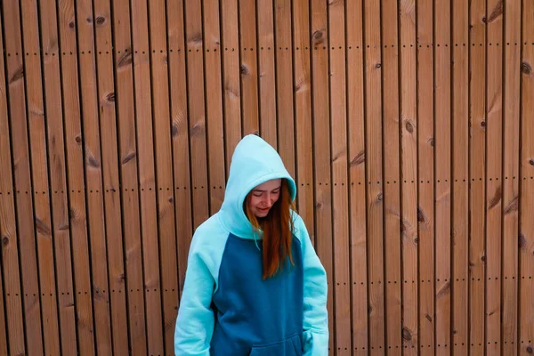 Roodharig Meisje Een Turquoise Snowboard Hoodie Houten Achtergrond Blauw — Stockfoto