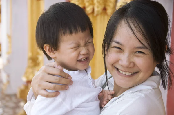 Átölelve, mosolygós kisfiú boldog édesanyja — Stock Fotó