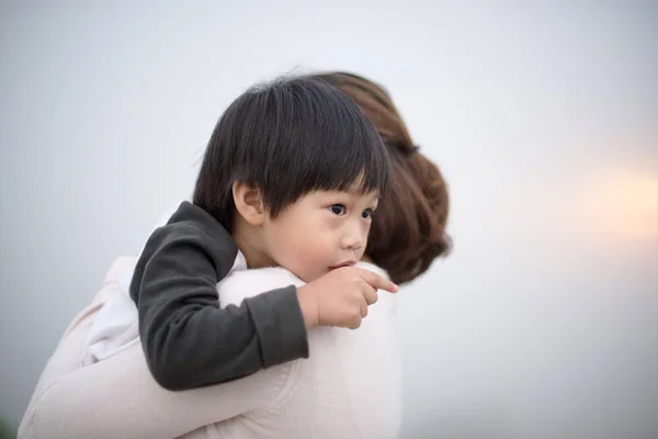 Mãe abraçando um menino aponta o dedo — Fotografia de Stock